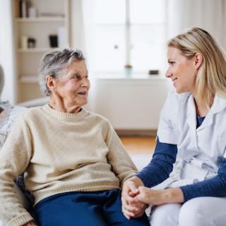 A caregiver shares a warm moment with an elderly individual, showcasing compassion and connection in a cozy indoor setting.
