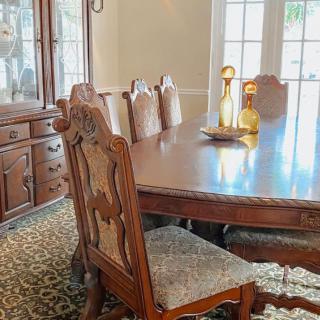 Elegant dining room with a large wooden table and ornate chairs.