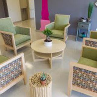 A modern waiting area with comfortable chairs and a central table featuring indoor plants.