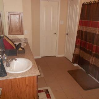 A clean bathroom with a sink, mirror, and a colorful shower curtain.
