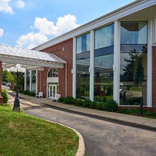 A modern building with large glass windows and a covered entrance walkway.