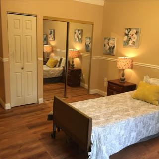 A cozy bedroom with a single bed, mirrored closet, and warm decor.