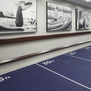 A modern gym interior featuring a workout track and motivational wall art.