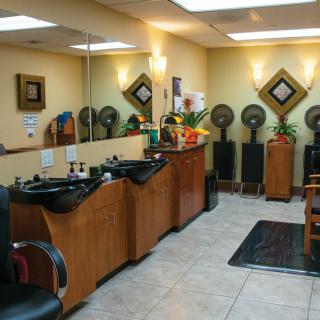 Interior view of a modern beauty salon with hair styling stations and equipment.