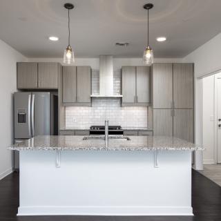 A modern kitchen with a central island and stainless steel appliances.
