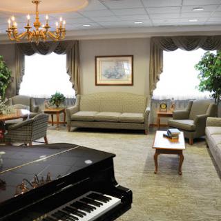 A cozy living room featuring elegant furniture and a grand piano, perfect for relaxation and gatherings.