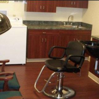 An interior of a hair salon with a styling chair and washing station.