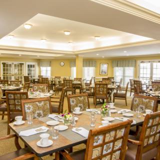 An elegant dining room setup with neatly arranged tables and chairs, ready for guests.