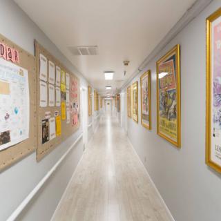 A school hallway lined with posters and notice boards on both sides.
