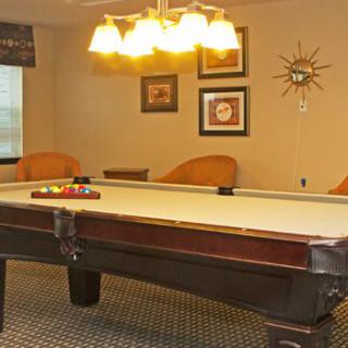 A cozy game room featuring a pool table and warm lighting.