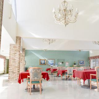 A bright and inviting dining area featuring red tablecloths and elegant chandeliers.