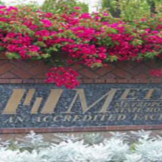 A decorative sign with flowers and greenery surrounding it.