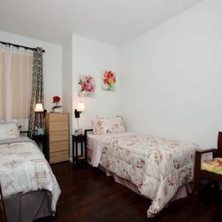 A cozy bedroom with two single beds adorned with floral bedding and decorations.