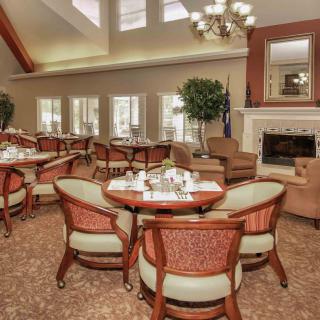 An elegant dining room with a cozy fireplace and neatly arranged tables and chairs.