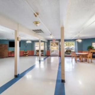 Spacious hall interior with columns and seating arrangements.