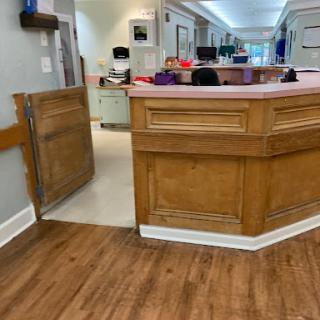 A view of the reception area in a healthcare facility, featuring a wooden counter and an inviting interior.