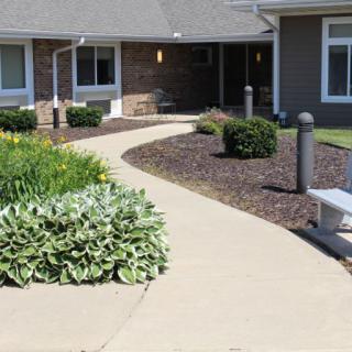 A landscaped garden pathway leading to a residential building entrance.