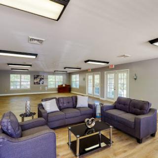 A modern living room featuring a cozy seating arrangement and ample natural light.