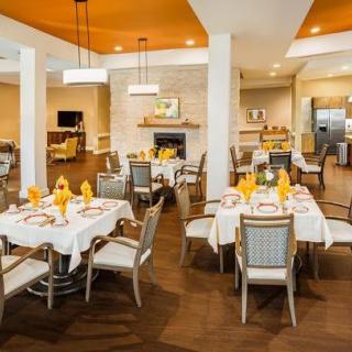 An elegant dining area with neatly arranged tables and chairs, featuring stylish lighting and decor.