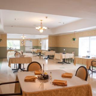 A spacious and elegantly designed dining area featuring well-arranged tables and chairs, perfect for a restaurant setting.