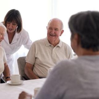 A group of seniors enjoying a conversation with a caregiver.