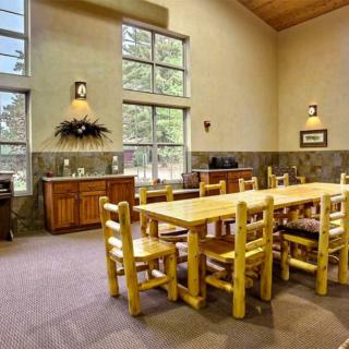 A cozy dining area featuring a wooden table and chairs with abundant natural light from large windows.