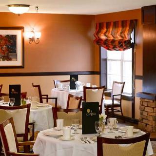 An elegantly designed restaurant dining area with neatly set tables and warm decor.