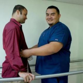A healthcare professional assists a patient during a physical therapy session.