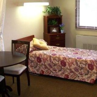 A cozy bedroom with a single bed and simple decor.