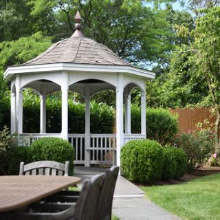 A charming gazebo nestled in a lush garden, inviting relaxation and enjoyment of nature.