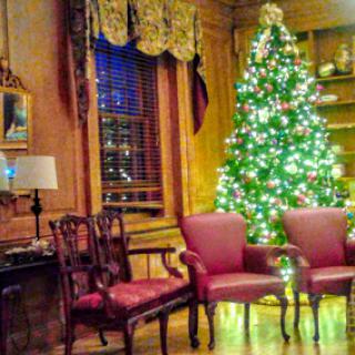 A cozy living room beautifully decorated for the holiday season with a glowing Christmas tree.