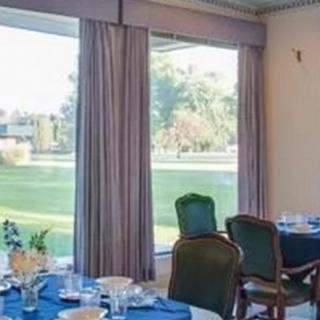A well-set dining room with large windows overlooking a scenic view.