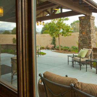 A cozy patio with outdoor seating and a view of a landscaped backyard.
