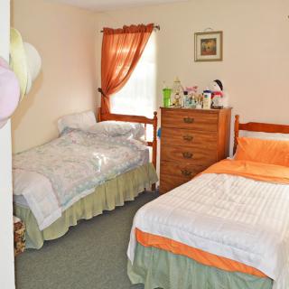 A cozy bedroom with two twin beds and a wooden dresser.