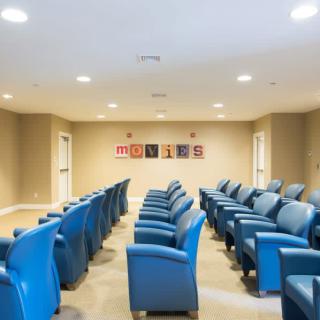 A well-arranged conference room with rows of blue chairs.