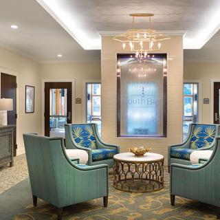 A modern hotel lobby with elegant seating and a chandelier.