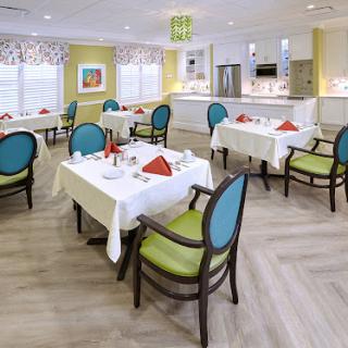 A bright and inviting dining area set up for a meal, featuring neatly arranged tables and colorful chairs.