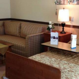 A cozy living room with a sofa, lamp, and tables arranged neatly.