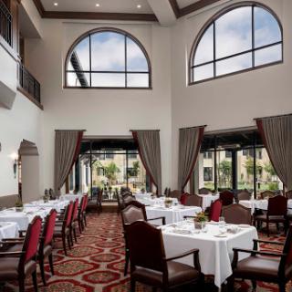An elegant dining area featuring spacious tables and large windows that invite natural light.