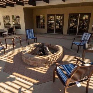 Outdoor patio area with a central fire pit and surrounding chairs.