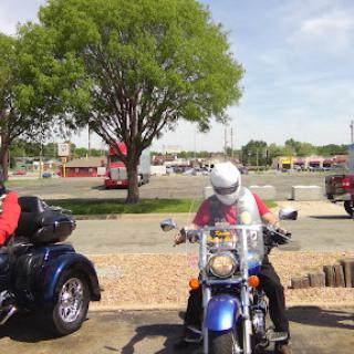 A motorcycle rider prepares to take off on a sunny day.