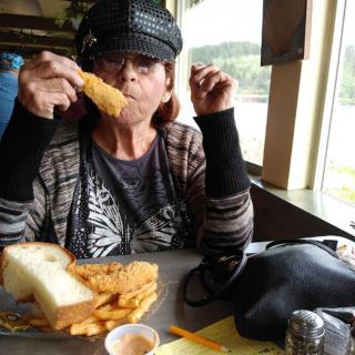 A person enjoying a meal of fish and chips at a restaurant.