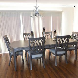 A modern dining room with a large wooden table and six matching chairs, featuring a chandelier and vertical blinds.