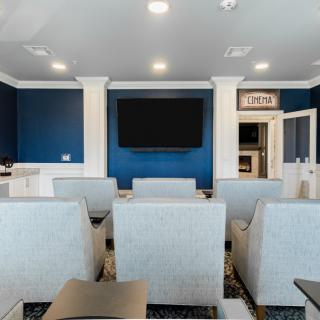 Modern theater room with comfortable seating and a large television.