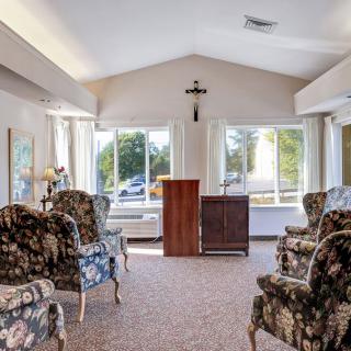 A cozy living room with patterned chairs and abundant natural light streaming through large windows.
