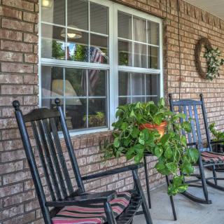 A cozy front porch with rocking chairs and potted plants.