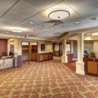 A spacious and well-lit lobby with carpeted floors and a reception area.