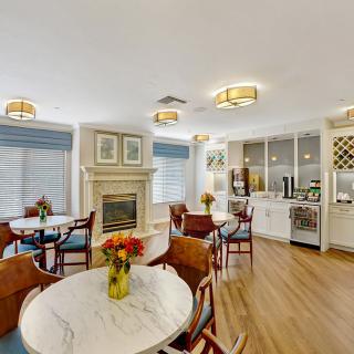 A modern and cozy dining area with a fireplace, featuring elegant tables and chairs.