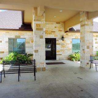 A welcoming entrance with stone architecture and benches for relaxation.