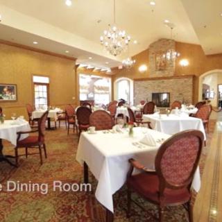 An elegant dining room with set tables and chandeliers.